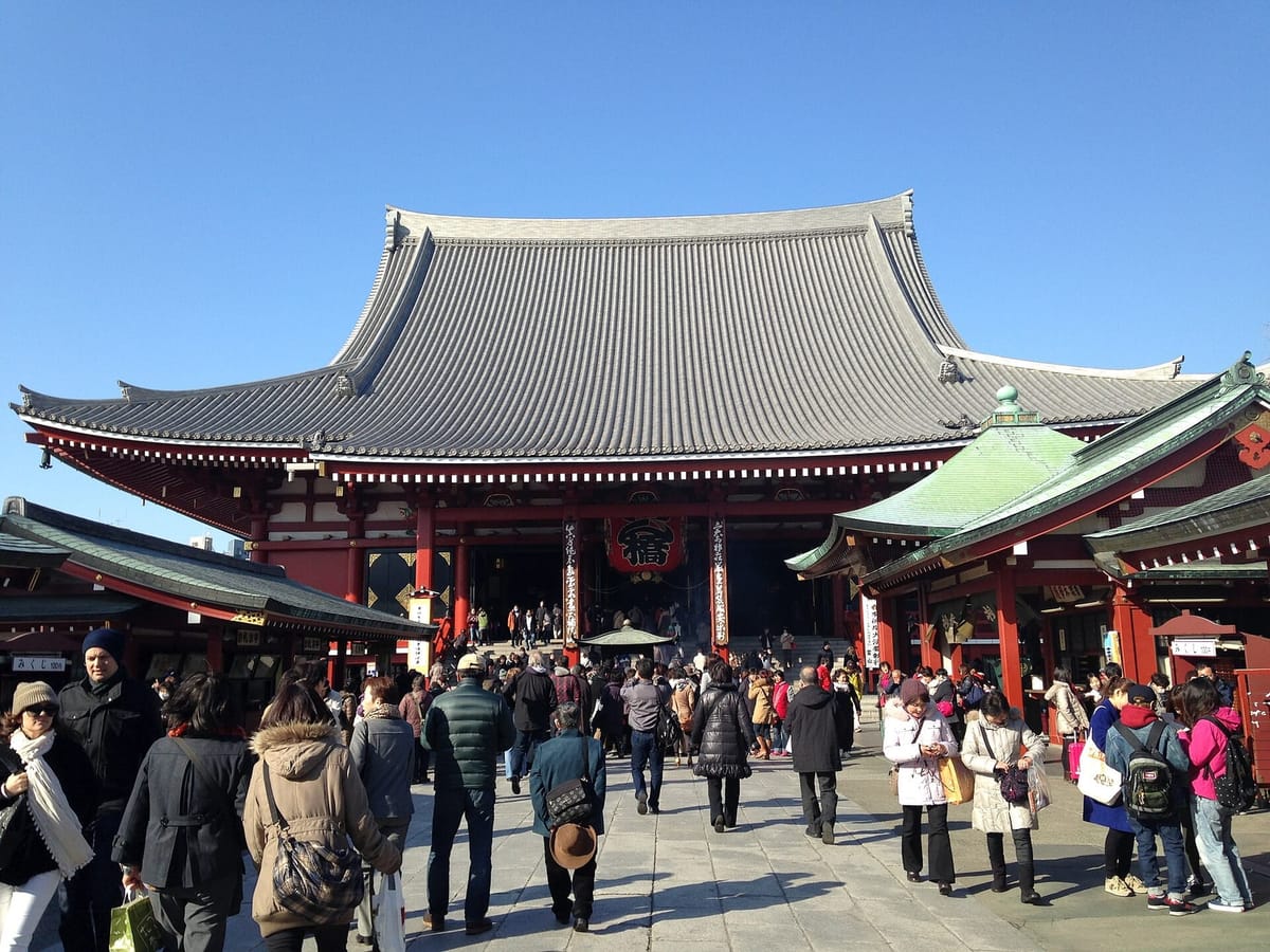 The main hall of Senso-ji with its deep tiled roof and the incense burner in front